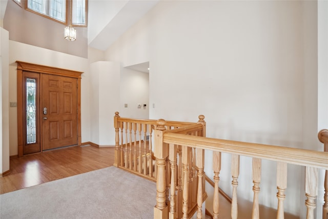 foyer with a towering ceiling and wood-type flooring