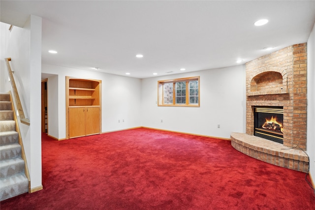 unfurnished living room featuring carpet floors, built in features, and a brick fireplace