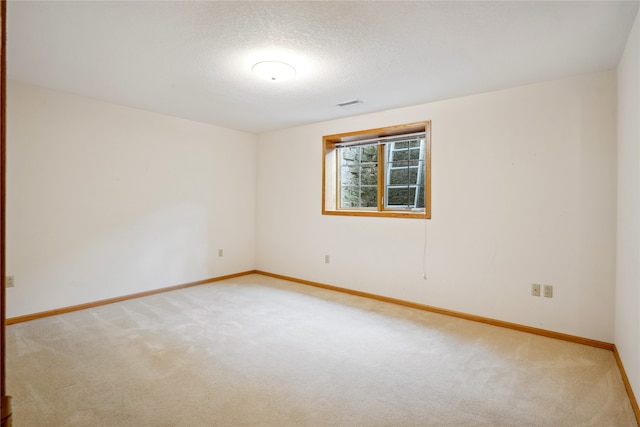 carpeted empty room featuring a textured ceiling