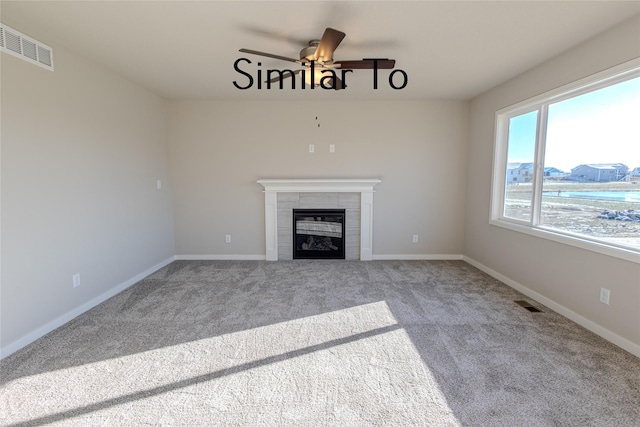 unfurnished living room featuring a fireplace, ceiling fan, and carpet