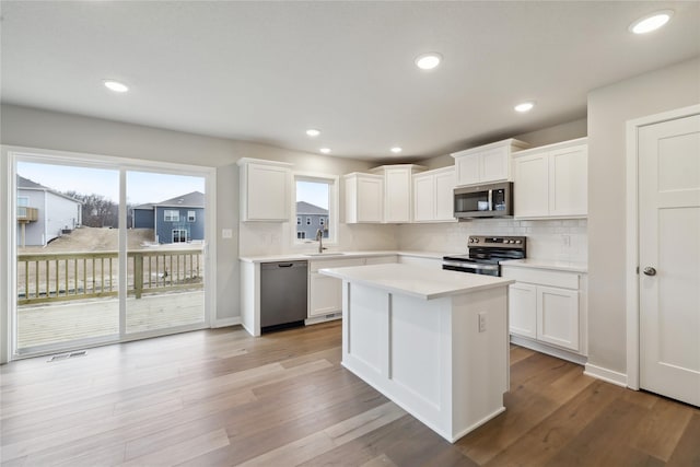 kitchen featuring stainless steel appliances, light countertops, a sink, and light wood-style flooring