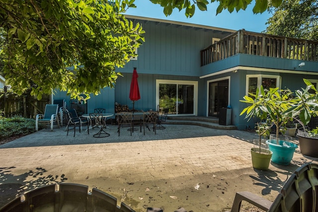 back of property featuring a balcony and a patio area