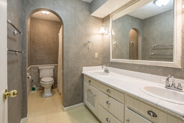 bathroom with vanity, a textured ceiling, tile patterned floors, and toilet