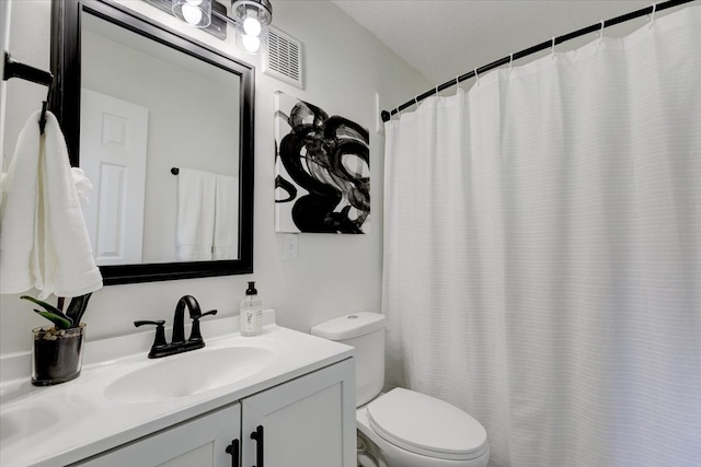 bathroom featuring vanity, a textured ceiling, and toilet