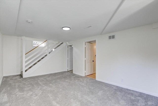 finished below grade area featuring baseboards, carpet, stairs, and visible vents