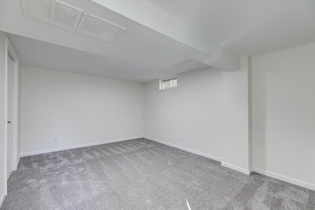 basement with baseboards, carpet flooring, and visible vents