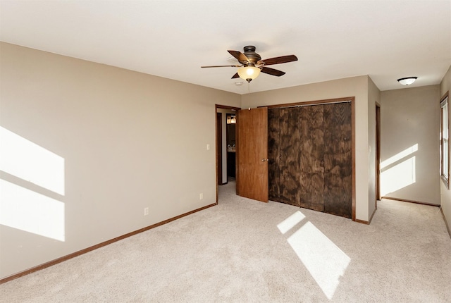 unfurnished bedroom with ceiling fan, light colored carpet, and a closet