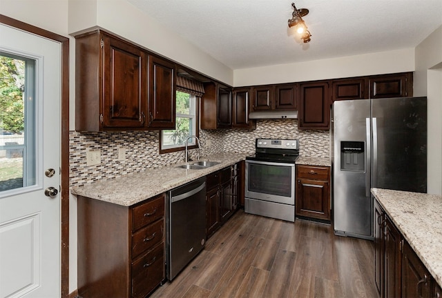 kitchen with appliances with stainless steel finishes, sink, and dark brown cabinets