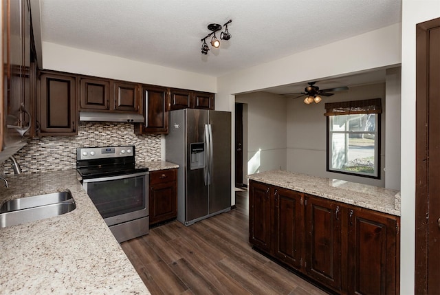 kitchen featuring a textured ceiling, dark brown cabinetry, stainless steel appliances, sink, and light stone counters