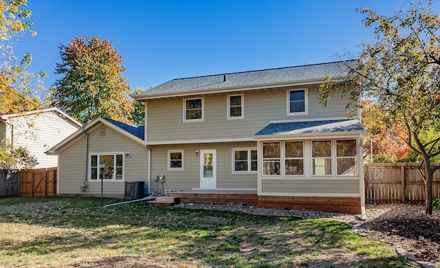 back of house with central AC and a lawn