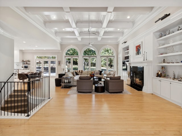 living room featuring light hardwood / wood-style floors, beamed ceiling, coffered ceiling, and a wealth of natural light