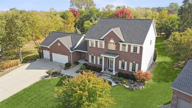 colonial house featuring a garage and a front lawn