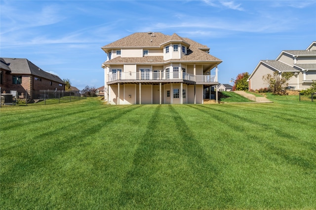 rear view of property with a deck and a yard