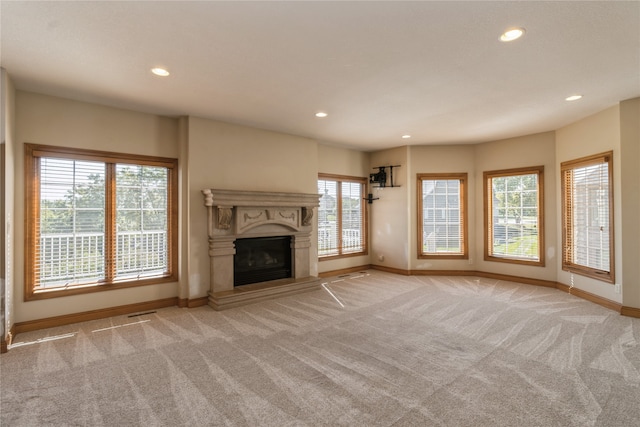 unfurnished living room featuring light carpet and plenty of natural light