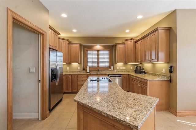 kitchen with light stone counters, stainless steel appliances, light tile patterned flooring, and a center island