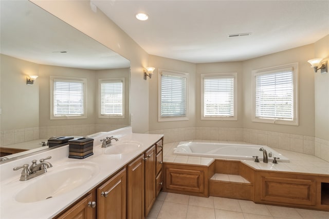 bathroom featuring vanity, tile patterned floors, plenty of natural light, and tiled bath