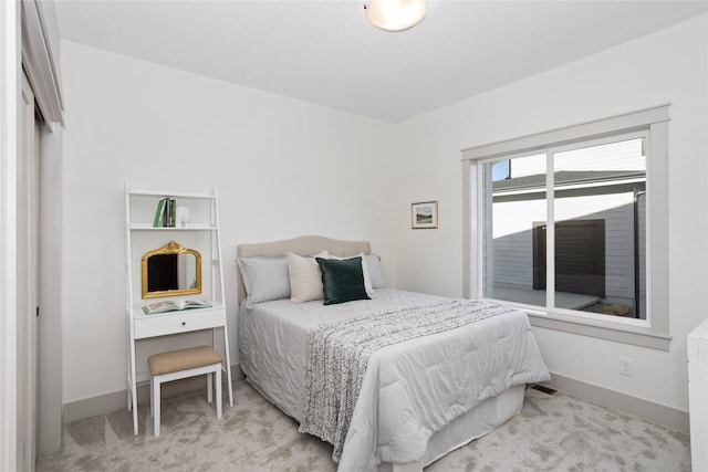 bedroom featuring light carpet and baseboards