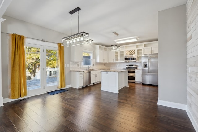 kitchen featuring a center island, dark hardwood / wood-style flooring, white cabinetry, stainless steel appliances, and pendant lighting