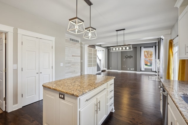 kitchen with dark wood-type flooring, white cabinets, light stone counters, and hanging light fixtures