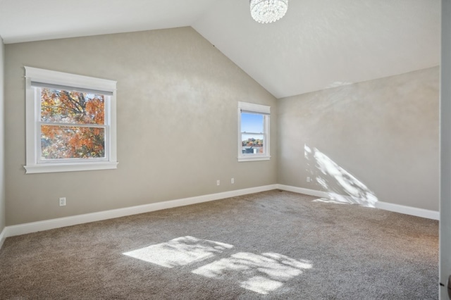 spare room featuring lofted ceiling, carpet floors, and a wealth of natural light