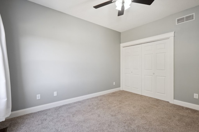 unfurnished bedroom featuring a closet, carpet flooring, and ceiling fan