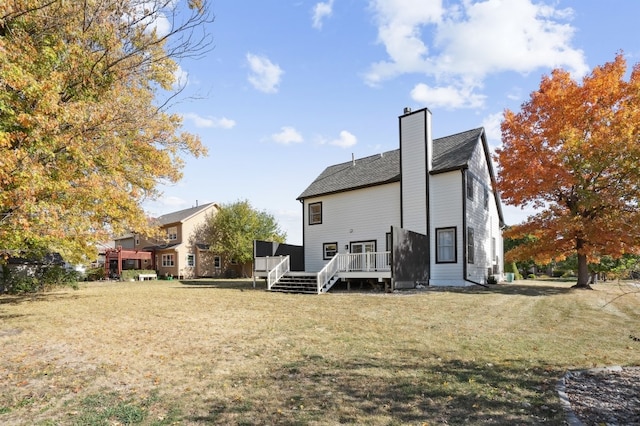 rear view of house featuring a deck and a lawn