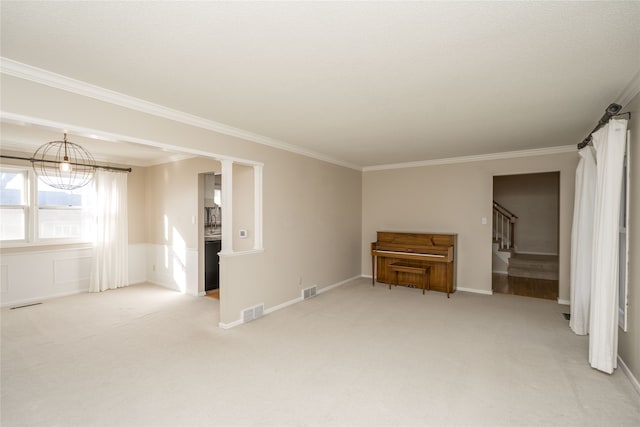 spare room with light colored carpet, decorative columns, and crown molding