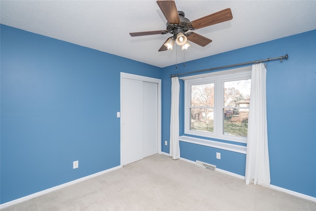 carpeted empty room with ceiling fan and a textured ceiling