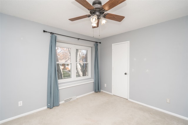 empty room with ceiling fan and light carpet