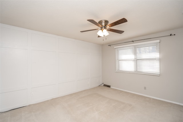 carpeted spare room featuring ceiling fan