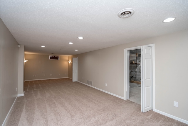 carpeted empty room with a textured ceiling