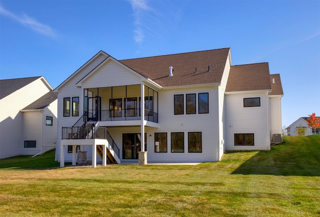 rear view of property with central AC, a yard, stairway, and a sunroom