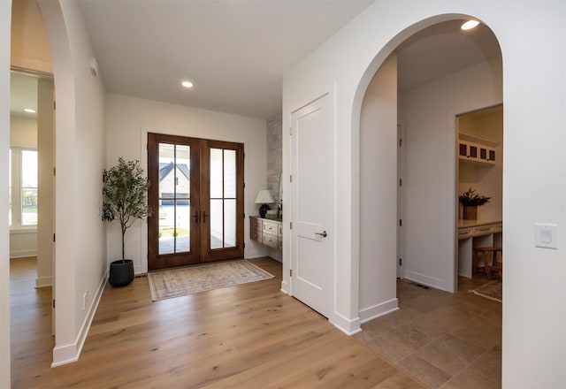 foyer with light wood-type flooring, recessed lighting, baseboards, and french doors