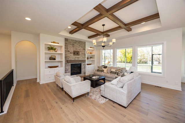 living area with coffered ceiling, a fireplace, light wood-style flooring, and baseboards