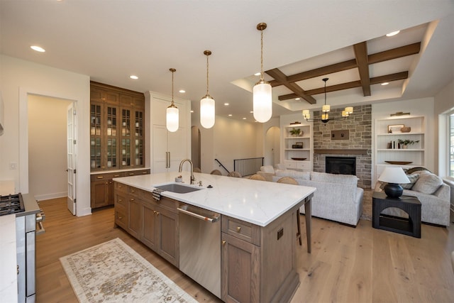 kitchen with arched walkways, light wood-style flooring, appliances with stainless steel finishes, a sink, and coffered ceiling