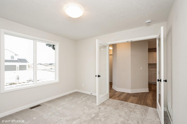 unfurnished bedroom featuring a textured ceiling and carpet