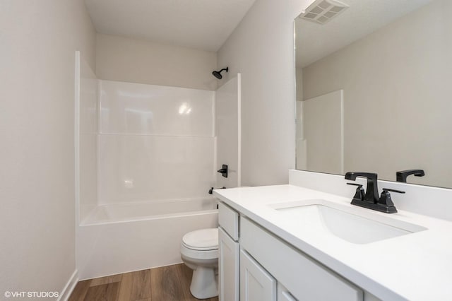 full bathroom featuring wood-type flooring, vanity, washtub / shower combination, and toilet