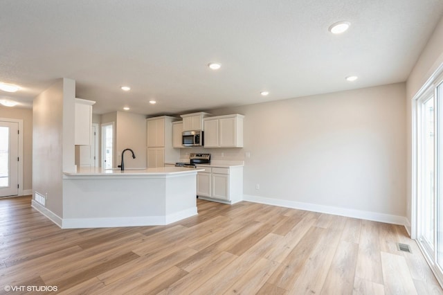 kitchen with white cabinetry, appliances with stainless steel finishes, and light hardwood / wood-style floors