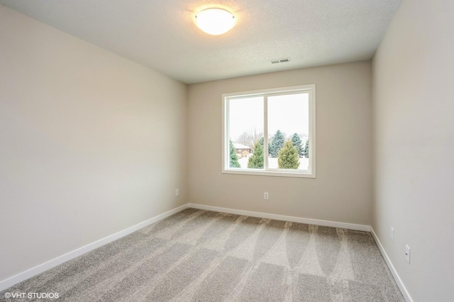 empty room with a textured ceiling and carpet flooring