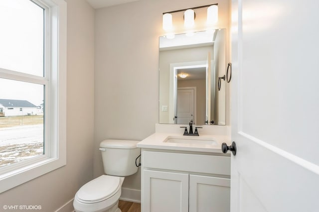 bathroom with vanity, a wealth of natural light, and toilet