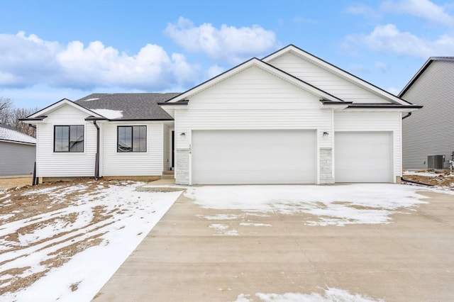 view of front of home with a garage and central air condition unit