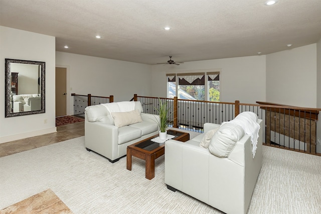 living room with a textured ceiling and ceiling fan