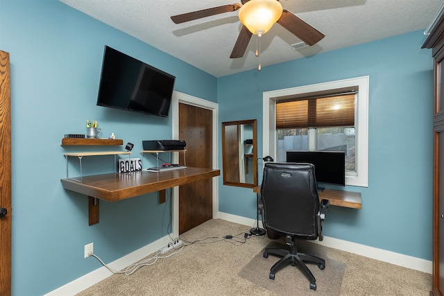 carpeted office space with ceiling fan and a textured ceiling