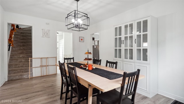 803 W Nevada St, Marshalltown, IA 50158 - dining space featuring a chandelier, light wood-style flooring, and stairway