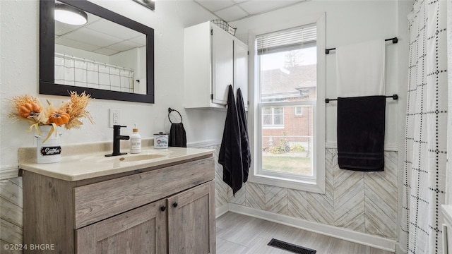 bathroom featuring vanity and a drop ceiling