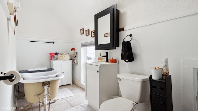 803 W Nevada St, Marshalltown, IA 50158 - bathroom featuring tile patterned floors, vaulted ceiling, toilet, and a sink