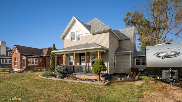 rear view of house featuring covered porch and a yard