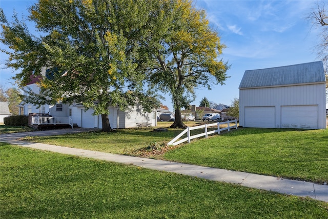 view of yard with a garage and an outbuilding