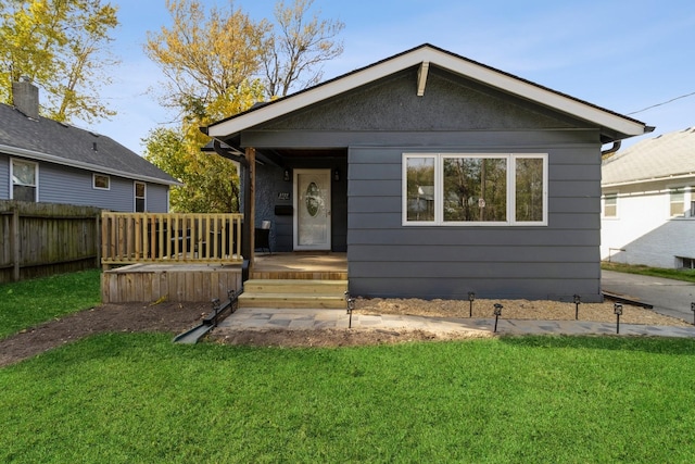 bungalow with a front lawn and fence