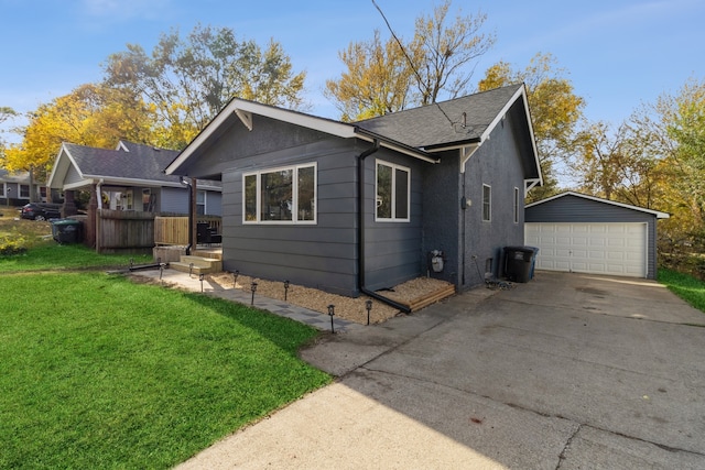 view of side of property featuring an outbuilding, a shingled roof, a lawn, and a detached garage